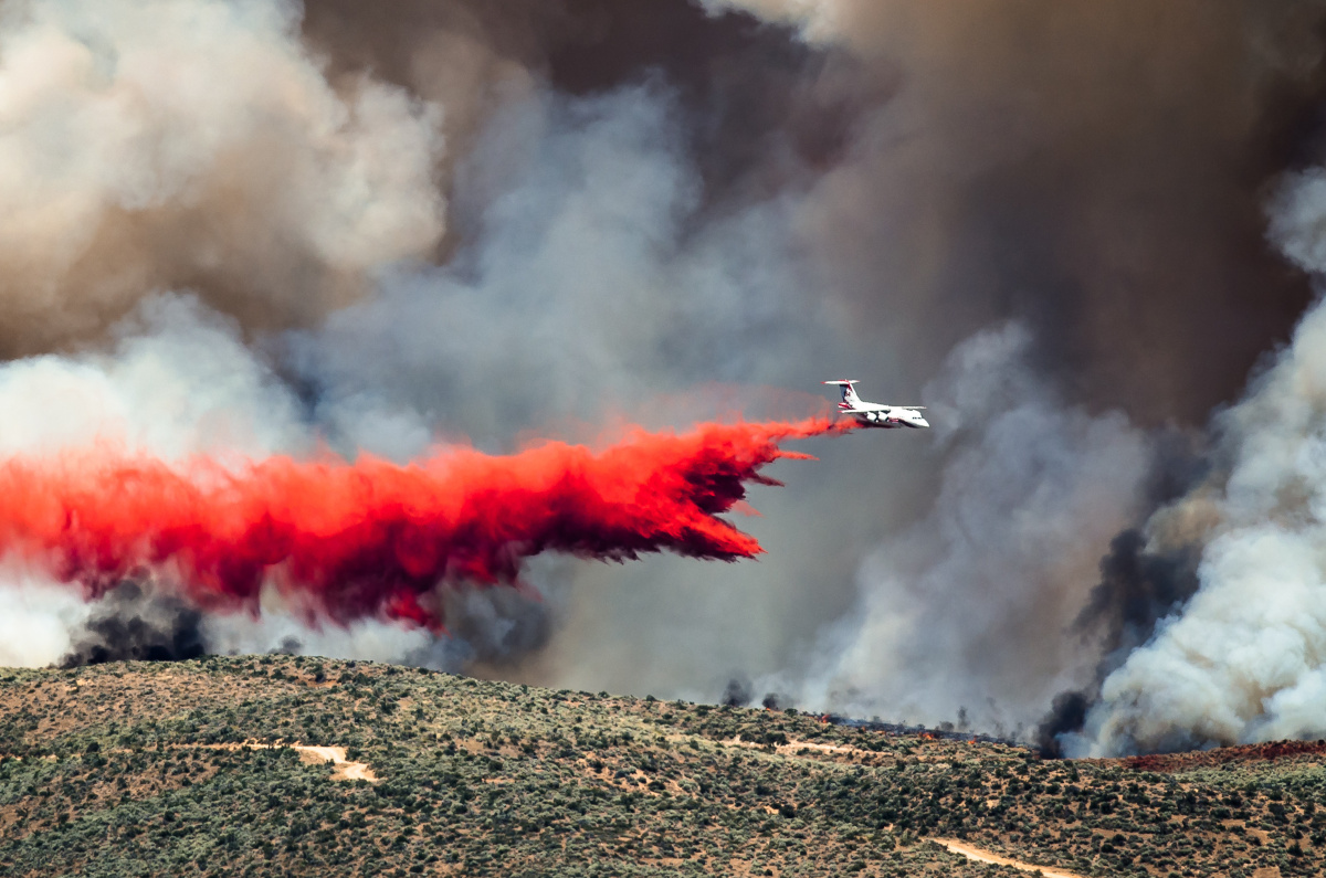 White Aircraft Dropping Fire Retardant