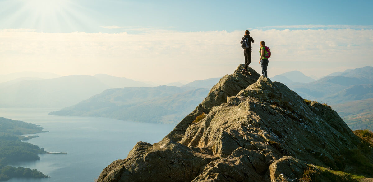 Two female hikers on top of the mountain enjoying valley view, Ben A