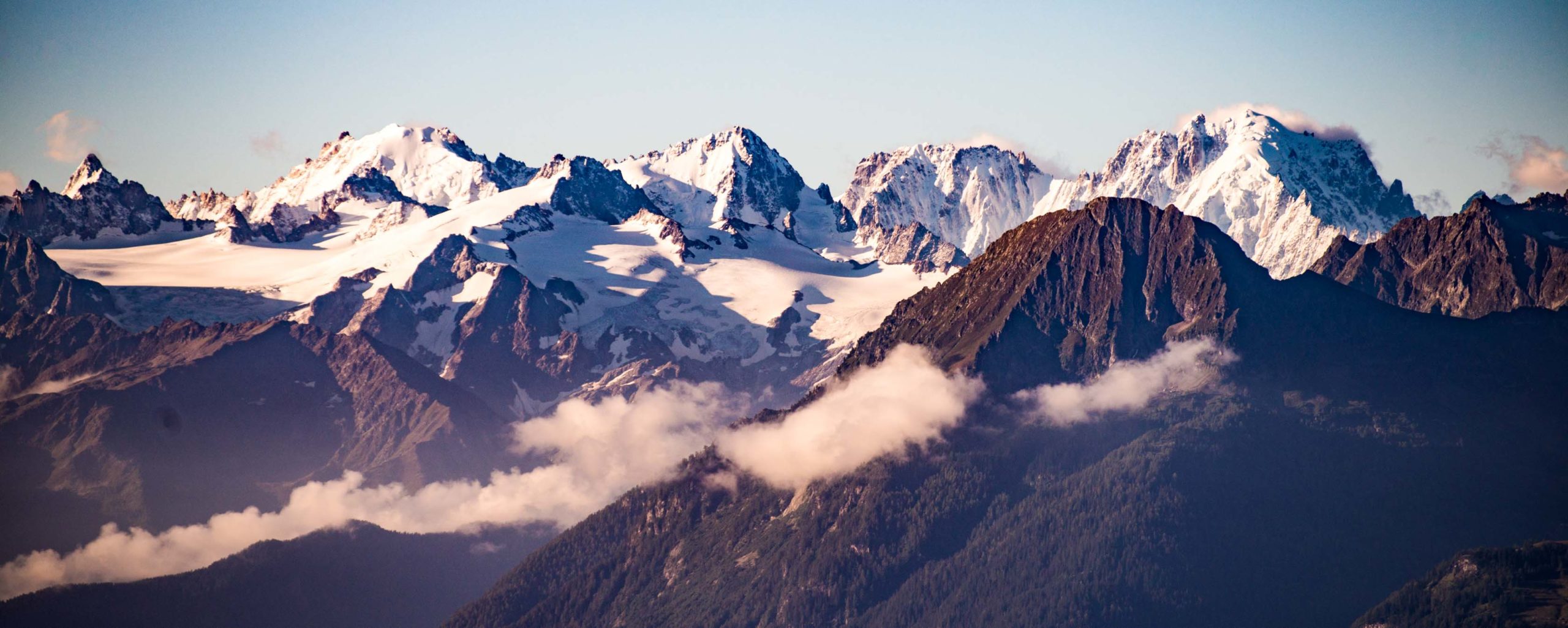 Snowcapped mountain range with clouds hanging between peaks