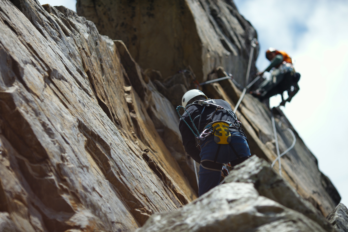 Abstract image of a two person rope of climbers on a rock tower.